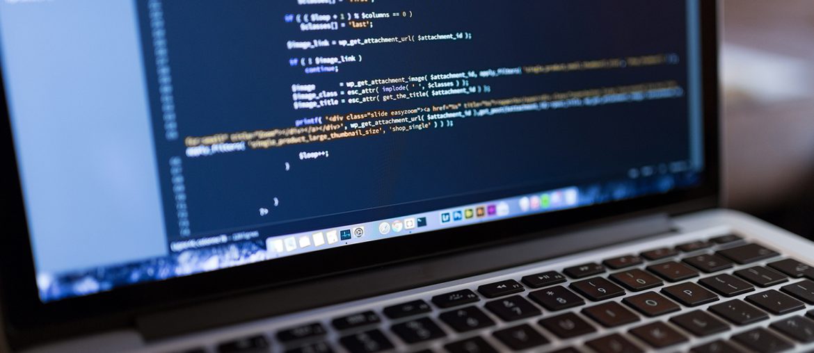 Vulnerabilities in recently discontinued WordPress plugins Laptop displaying open source code editor with highlighted syntax on the screen.