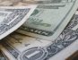 Close-up of assorted US dollar bills overlapping, featuring one and twenty-dollar denominations.