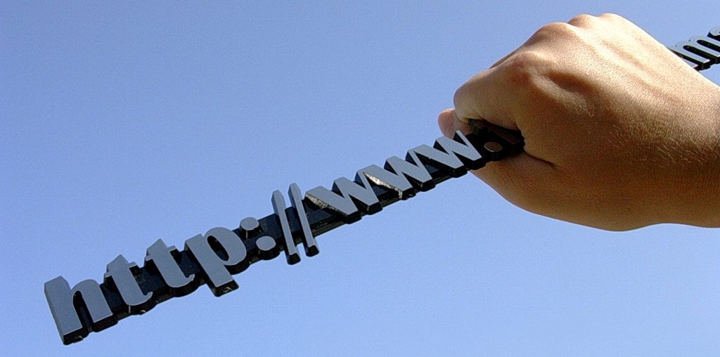 Hand gripping 3D http://www letters against clear blue sky, symbolizing internet connectivity and web power.