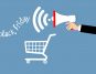 Hand holding megaphone with sound waves near shopping cart and Black Friday text on blue background.